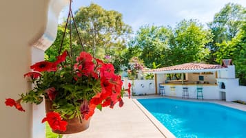 Una piscina al aire libre de temporada, sombrillas