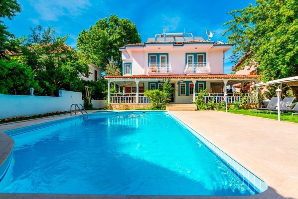 Piscine extérieure en saison, parasols, chaises longues