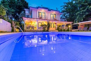 Una piscina al aire libre de temporada, sombrillas