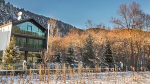 A modern building with large glass windows, surrounded by a snowy landscape and trees. - Abant Lotus Otel (Bolu)