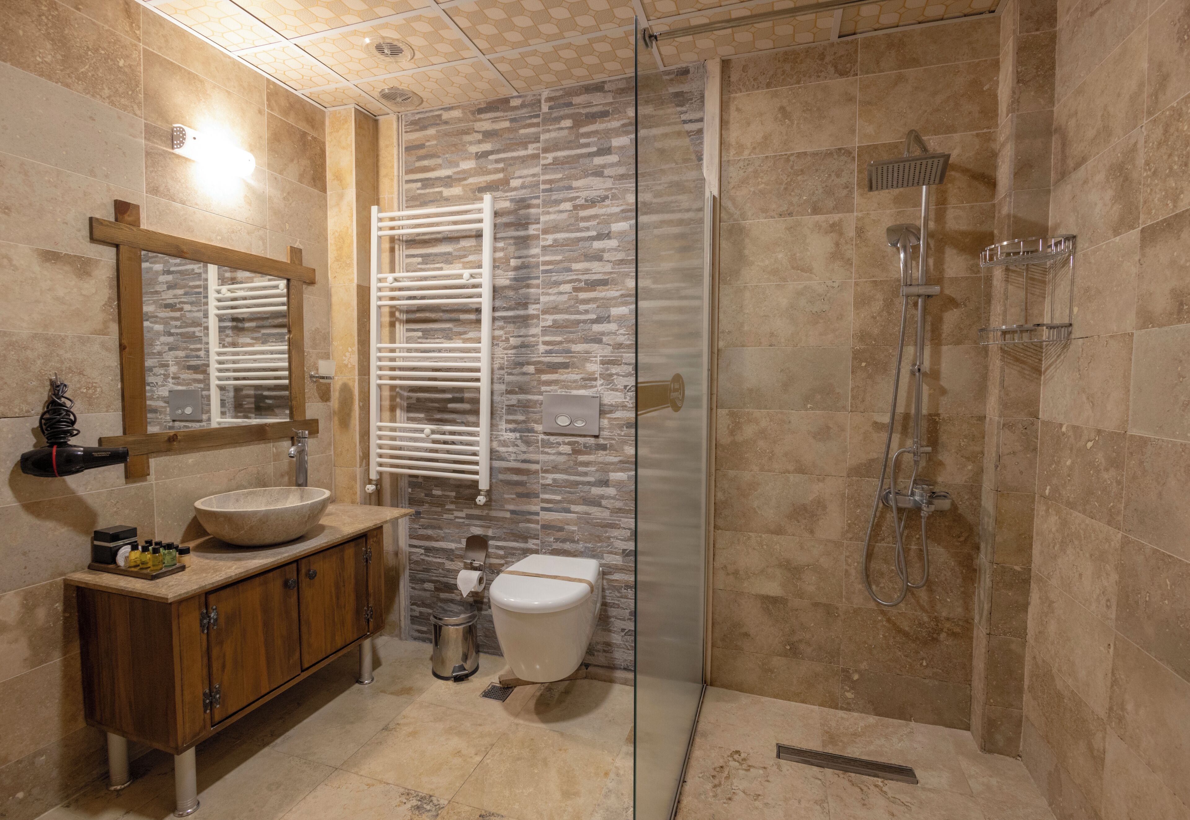 A modern bathroom with a glass-enclosed shower, a wooden vanity with a sink, and a toilet.