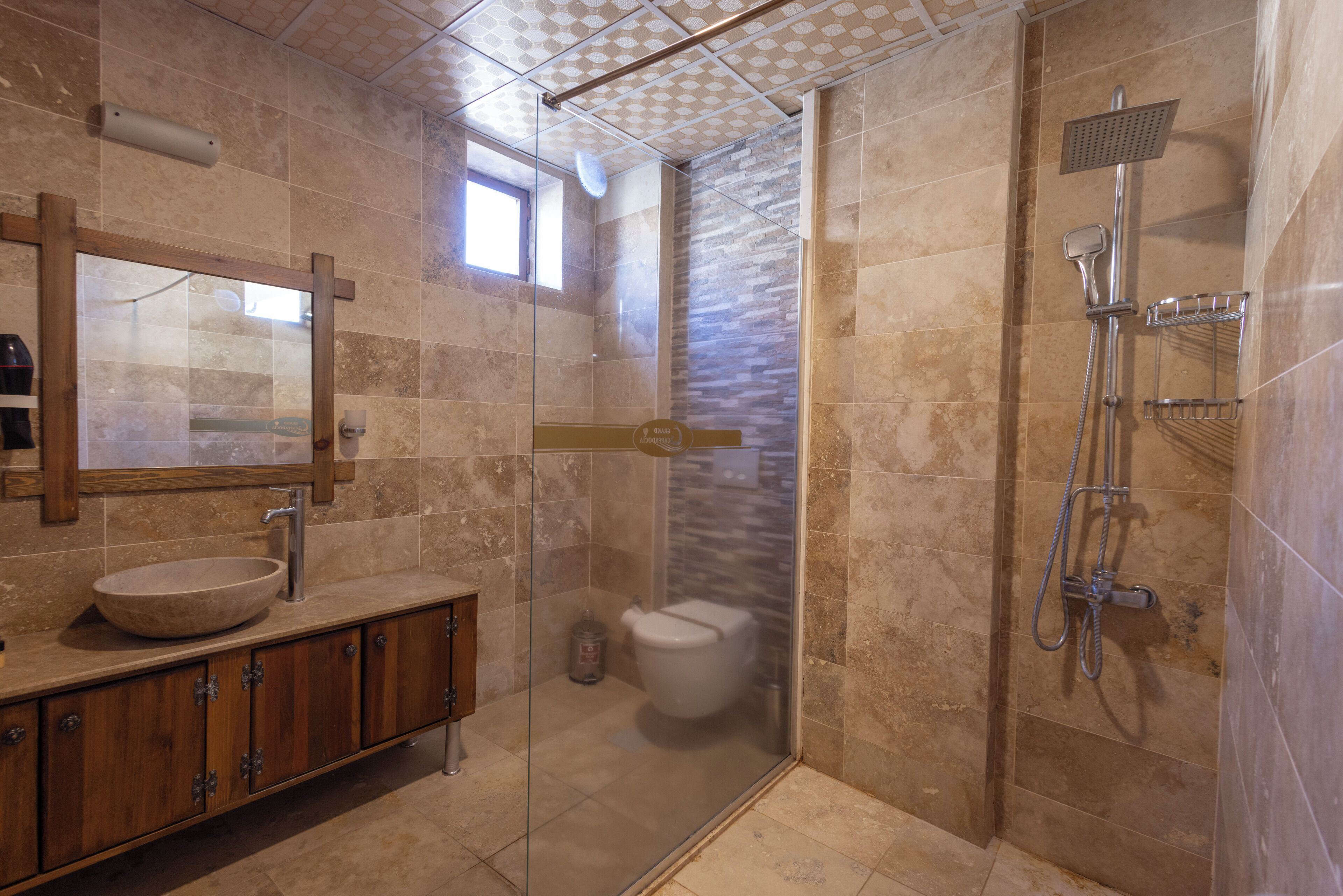 Une salle de bain moderne avec une douche à parois de verre, un meuble-lavabo en bois et un grand miroir.