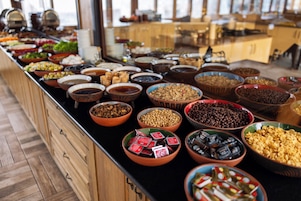 Un bufé con distintos alimentos servidos en boles y recipientes.