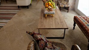 A spacious living room with a wooden coffee table, wicker chairs, and a large potted plant. - Lanterne Magiche Ortigia (Syracuse)
