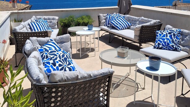 A terrace with outdoor furniture, including sofas and chairs, arranged around a central table. - Lanterne Magiche Ortigia (Syracuse)