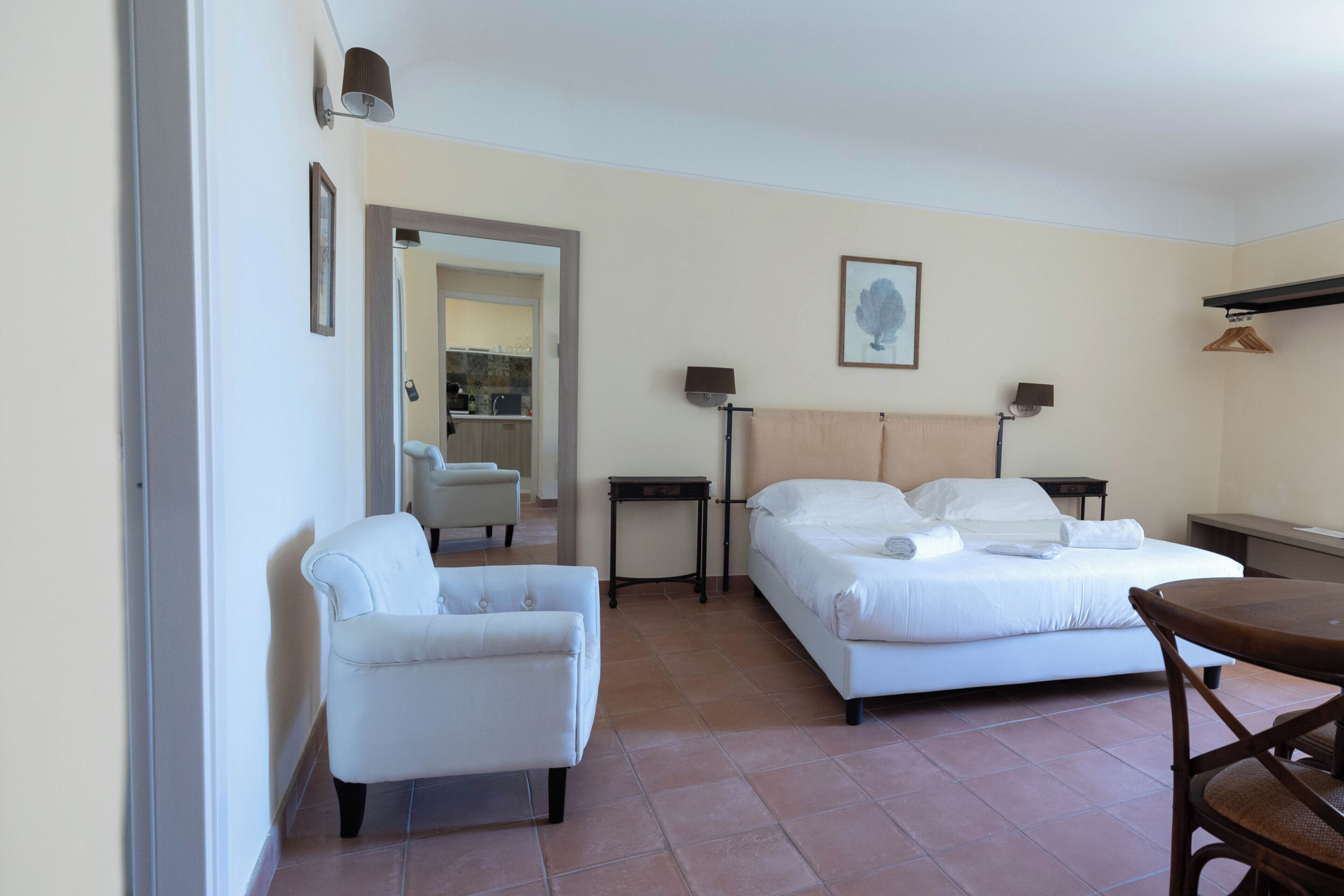 Une chambre d’hôtel avec deux lits, une chaise, une table et un miroir.