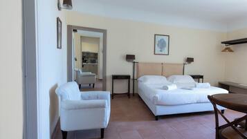 Habitación de hotel con dos camas, una silla, una mesa y un espejo.