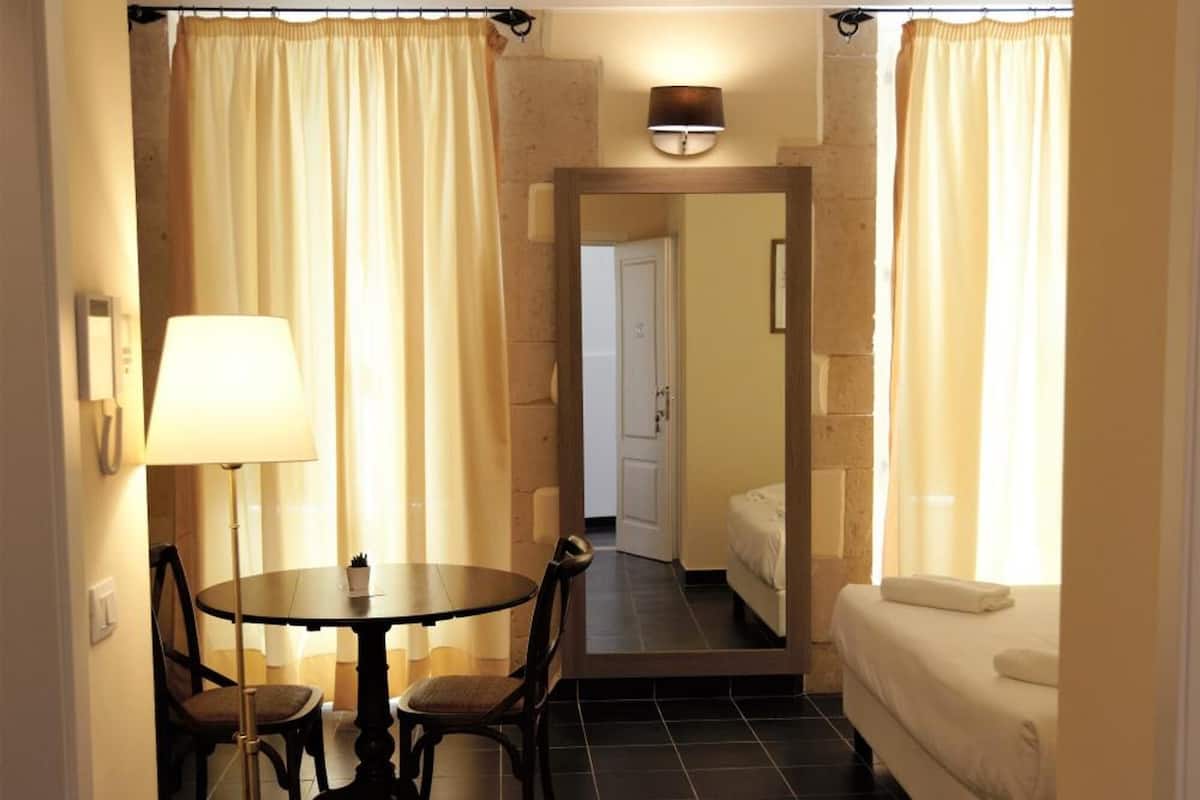 Ein Hotelzimmer mit Essbereich, einem Bett und einem durchgegangenen Badezimmer.