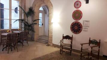 Ein Zimmer mit Essbereich, einer großen Topfpflanze und drei Dartscheiben an der Wand.