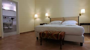 A large bed with a wooden headboard, two bedside lamps, and a patterned throw blanket.