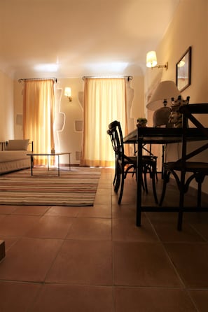 Un comedor con mesa y sillas, un sofá y cortinas.