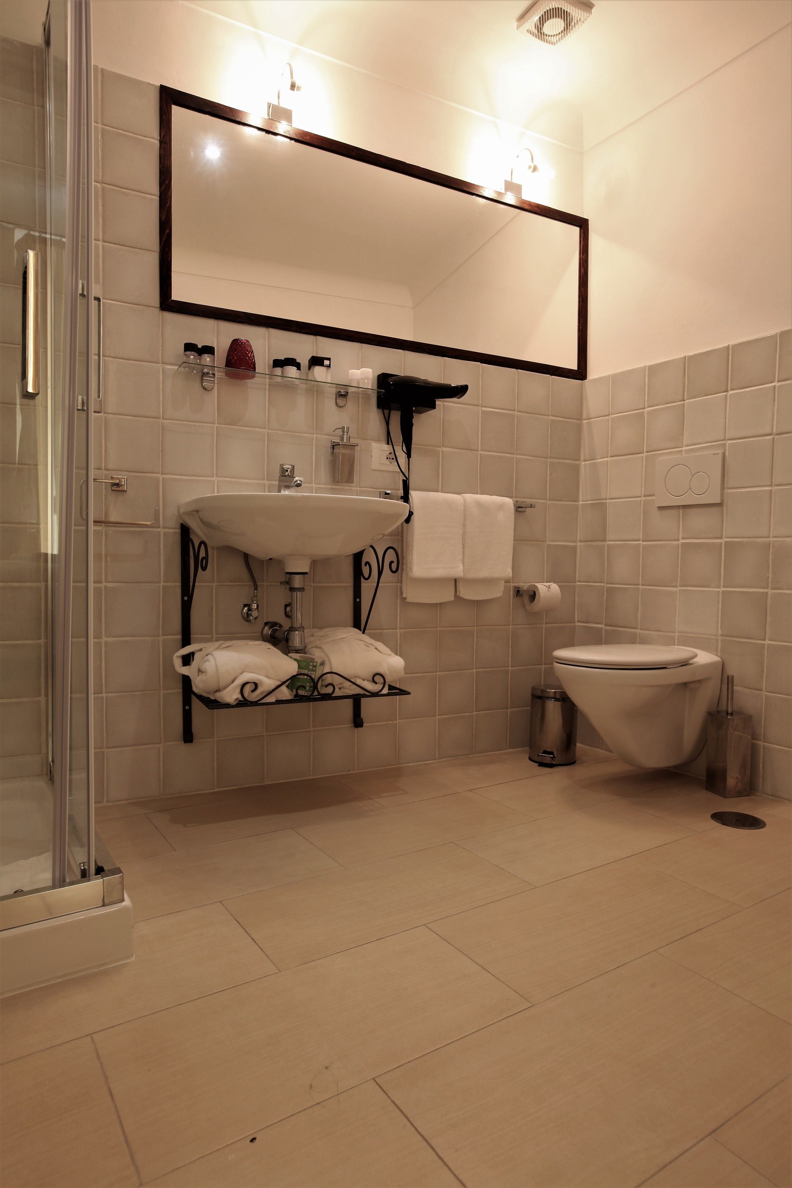 Un baño con lavamanos, espejo e inodoro.