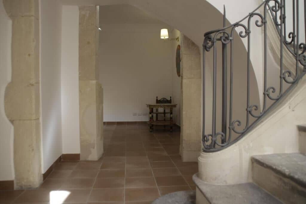A staircase with ornate metal railings leading to a landing.
