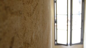 Un couloir étroit, doté d’une moquette rouge, d’un mur blanc et d’une fenêtre à cadre noir.