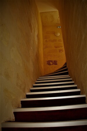 Un escalier avec une rampe en bois et un mur à texture.