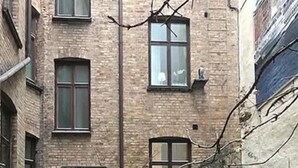 A courtyard with a brick building, a wooden door, and outdoor furniture including a table and chairs. - H5 Hotel (Helsingborg)