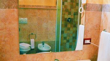 Un bagno con uno specchio grande, un lavandino, una doccia e un portascopevoli.