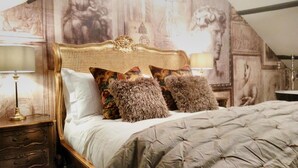 A bedroom with a large bed, ornate headboard, and multiple pillows. - Town House at Brecon (Brecon)