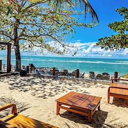 Na praia, espreguiçadeiras, guarda-sóis, bar na praia