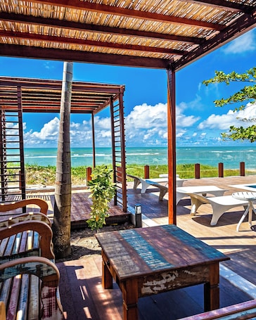 On the beach, sun loungers, beach bar. Hotel Espelho D’Água Arraial Beach Club