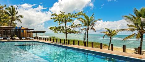 Una piscina al aire libre, sillones reclinables de piscina