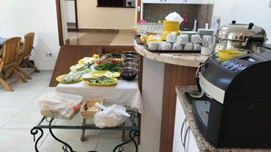 A kitchen with a dining table set for a meal, a grill, and various kitchen utensils. - Lacin Apart Otel (Datça)