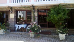 A building with a balcony, potted plants, and a table outside. - Lacin Apart Otel (Datça)