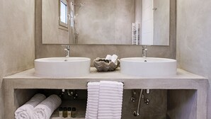 Une salle de bain moderne avec deux lavabos, un grand miroir et un porte-serviettes.