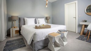 Une chambre à coucher avec un lit, des tables de chevet, un bureau et une chaise.