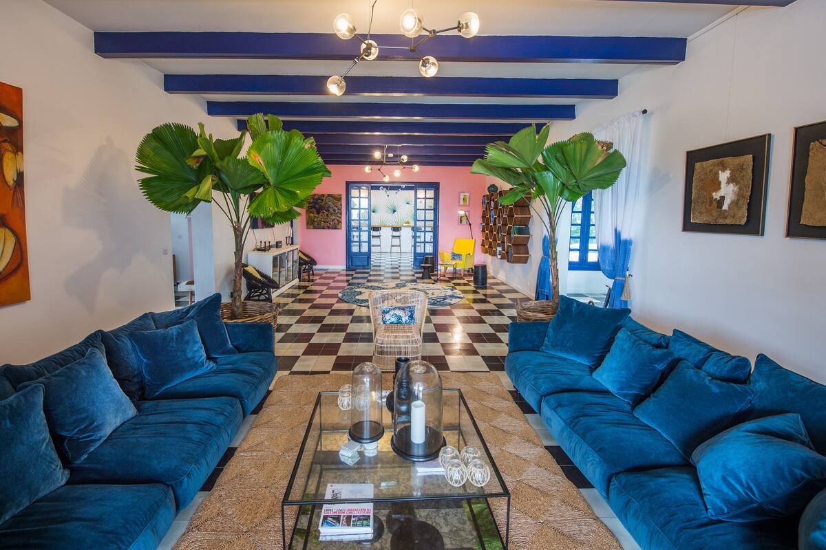A spacious living area with two blue sofas, a coffee table, and a checkered floor.