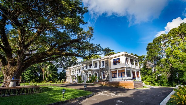 A large, two-story building with a symmetrical facade, arched windows, and a central entrance. - Apolline Martinique (Fort-de-France)
