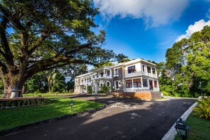 A large, two-story building with a symmetrical facade, arched windows, and a central entrance. - Apolline Martinique (Fort-de-France)