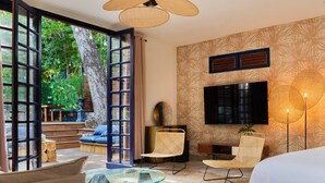 A modern living room with a glass coffee table, a sofa, and a TV mounted on the wall. - Apolline Martinique (Fort-de-France)