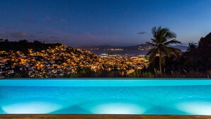 A pool with a view of a cityscape at dusk. - Apolline Martinique (Fort-de-France)