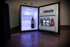 An open refrigerator with shelves containing bottles and glasses. - Domus Flaviae (Rome)