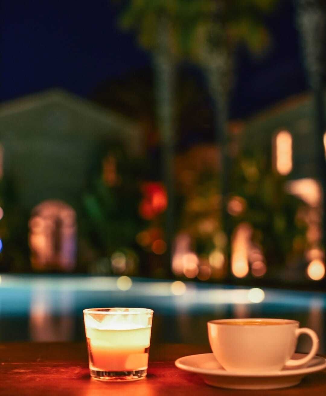 A dimly lit indoor setting with a pool in the background.