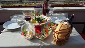 A table set for a meal with various dishes, glasses, and a bottle of wine. - Hotel Villa Marina (Bandirma)