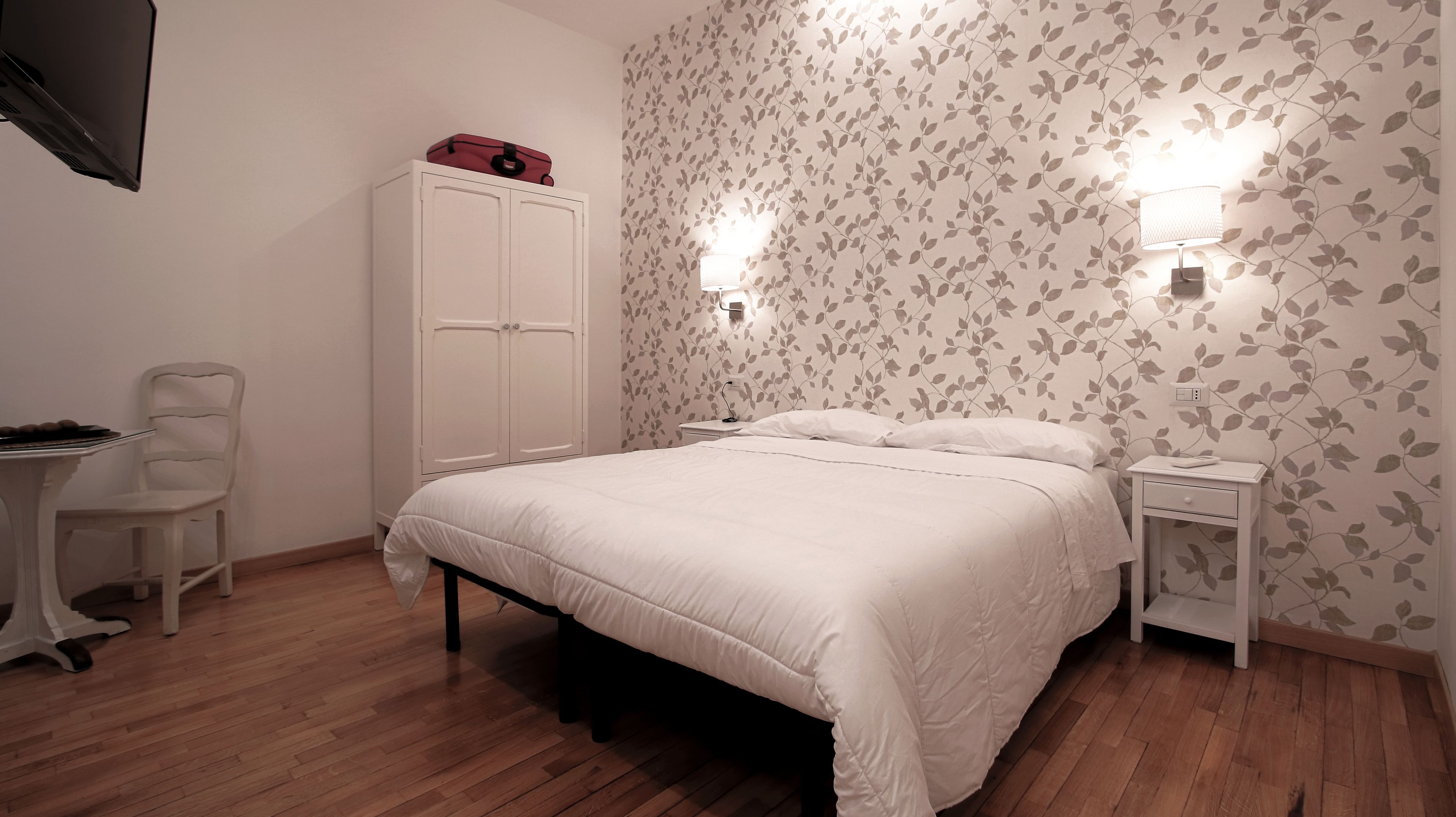 Une chambre à coucher avec un lit, une armoire, un bureau et une chaise.