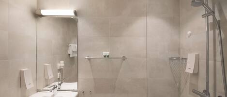 A modern bathroom with a sink, mirror, and shower.