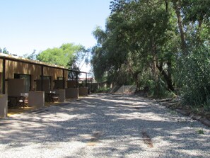 A building with multiple rooms, a gravel driveway, and surrounding trees.
