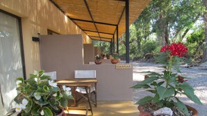 Un espace extérieur aménagé avec des pots en terre cuite, une table en bois et des chaises.