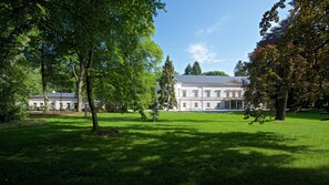 A large, white building with a symmetrical facade and a central entrance. - Zámek Ratměřice Hotel & Resort (Ratmerice)