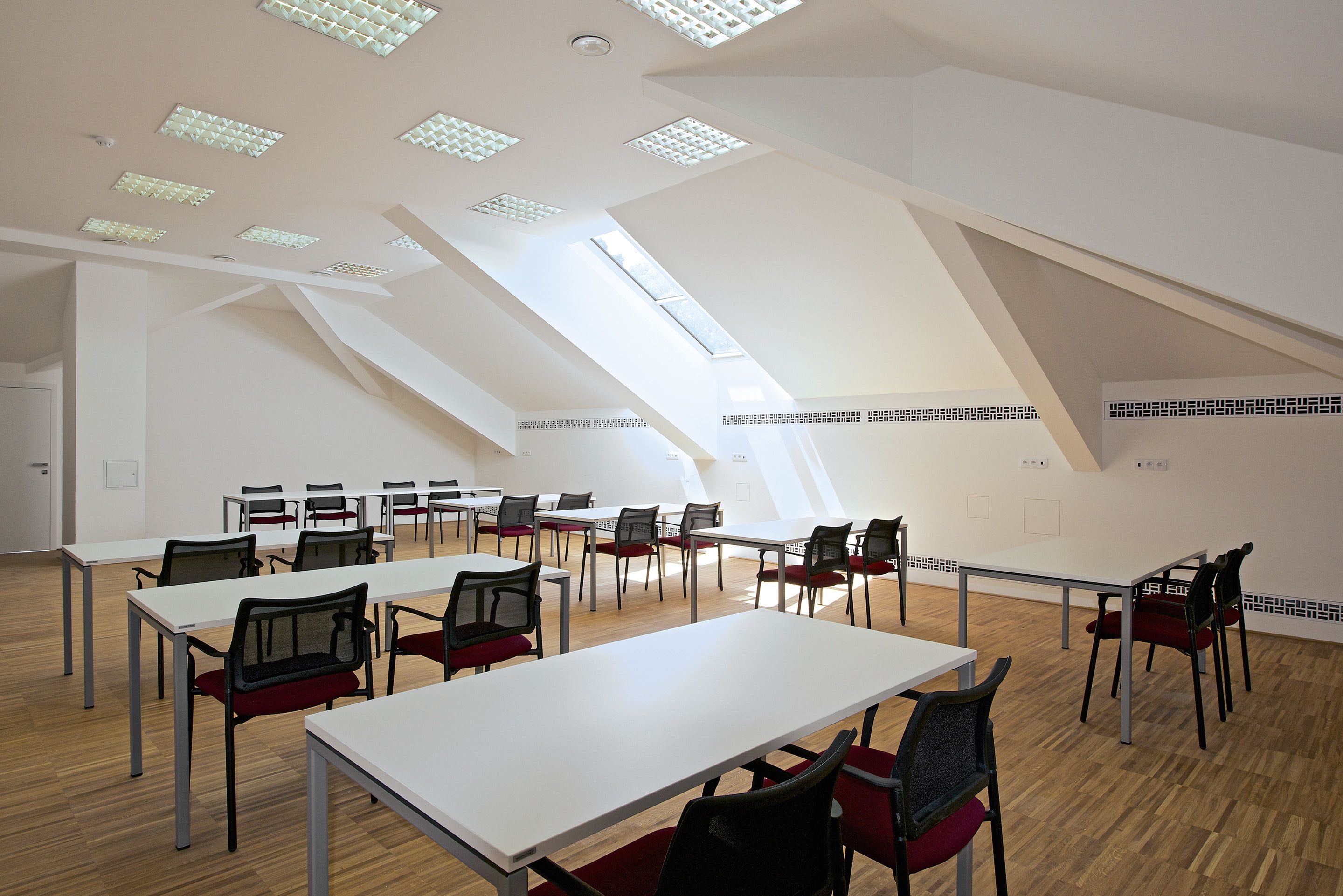 A spacious room with high ceilings, skylights, and a modern design.