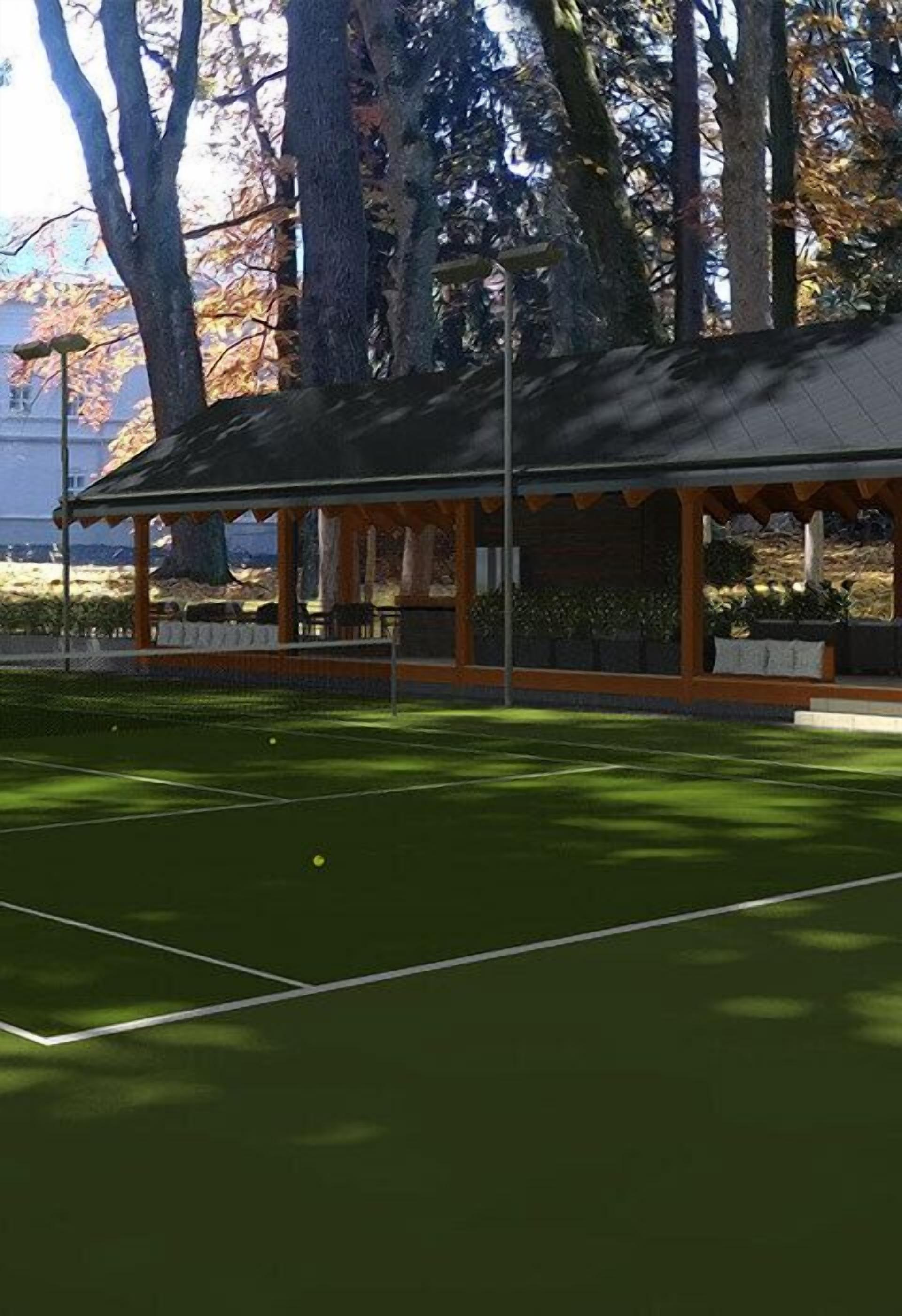 Una cancha de tenis con pabellón techado, rodeada de árboles.
