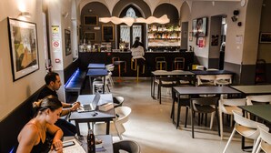 Un restaurante con mesas, sillas, una zona de bar y una barra.