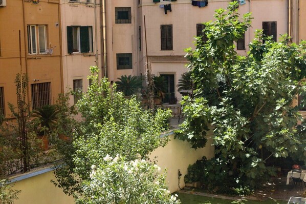 A courtyard with a variety of plants and a small table with chairs.
