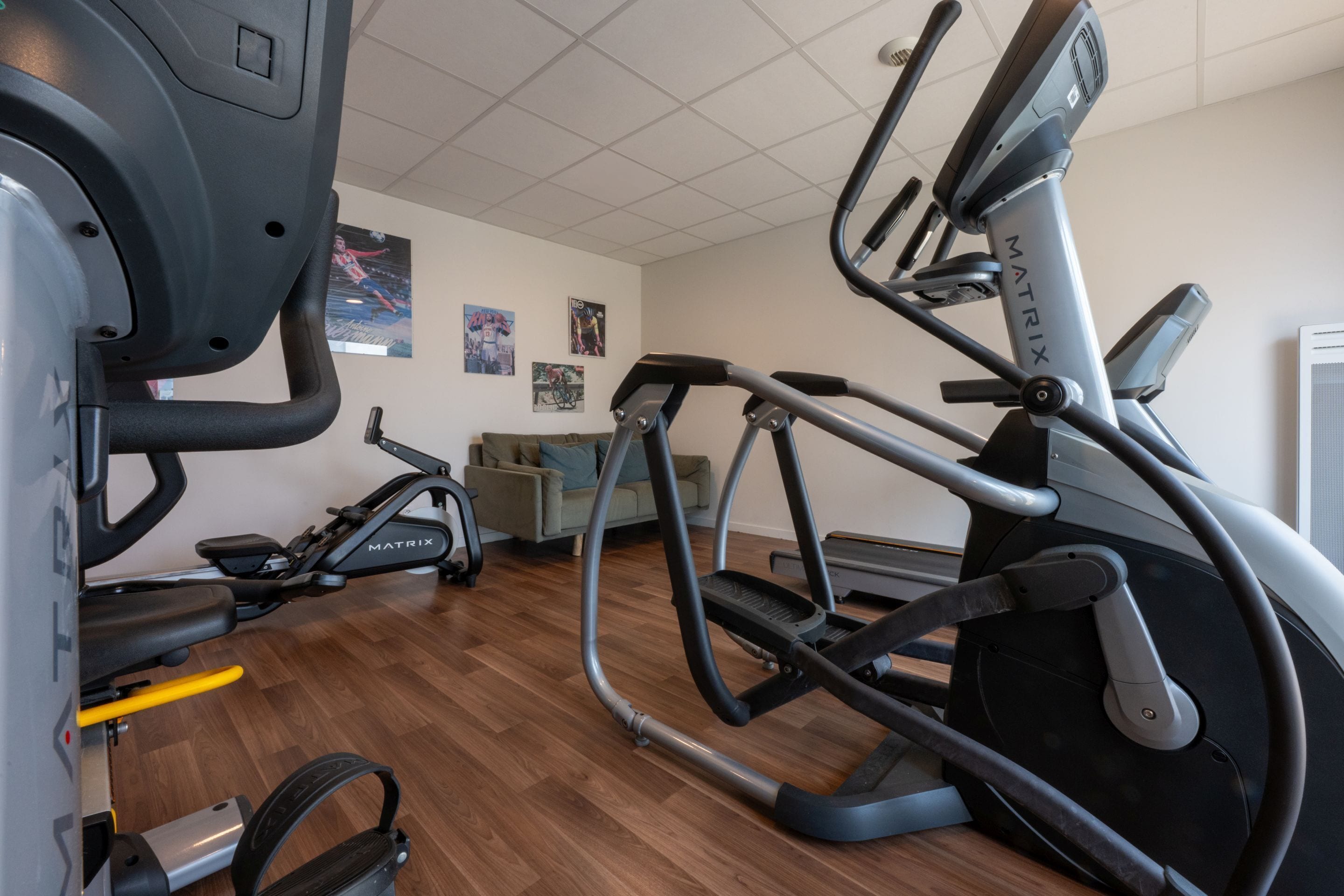 Un gimnasio con equipos de ejercicio variados, incluyendo cintas de correr y bicicletas estáticas.