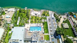 Vista aérea de um resort com piscina, área de praia e estacionamento.