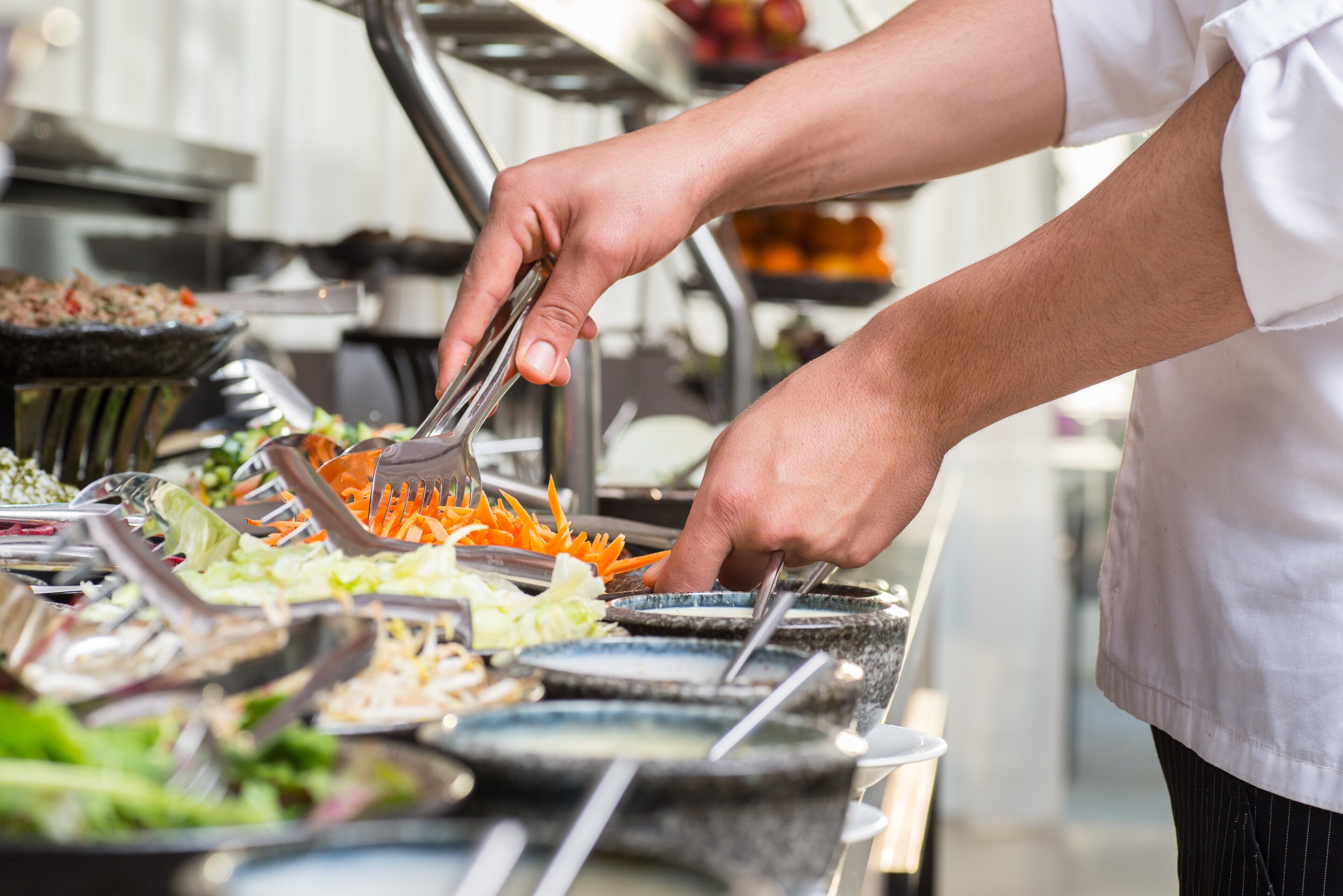 A buffet setup with various food items and utensils.