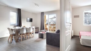 Un salon moderne comprenant un coin repas, un canapé et un lit.